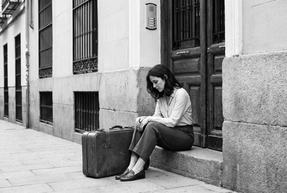 Mujer con maleta en el portal, desahucio