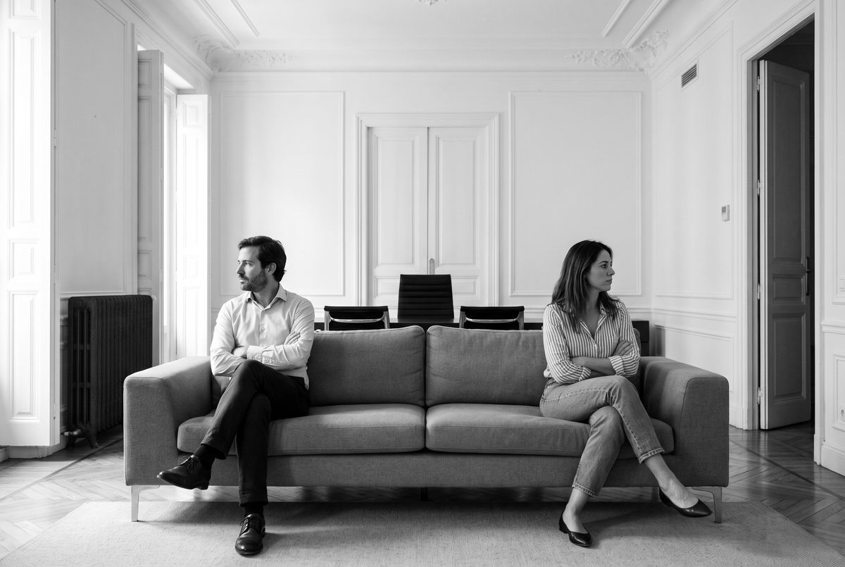 Pareja distanciada en el sofá, separación